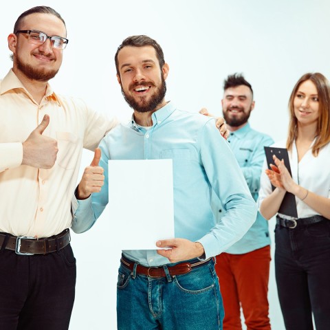 Jefe aprobando y felicitando a un joven empleado exitoso durante una reunión de trabajo, representando reconocimiento profesional y buen clima laboral