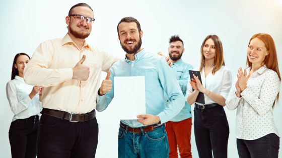 Jefe aprobando y felicitando a un joven empleado exitoso durante una reunión de trabajo, representando reconocimiento profesional y buen clima laboral