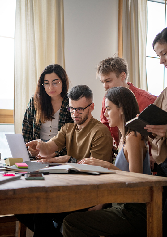 Jovenes reunidos para aprender frente a una laptop en una sesión de estudio.e