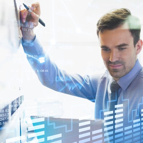 Hombre analizando datos y gráficos, habilidades enseñadas en el curso de Gestión de Riesgos para Entidades Financieras de la USFQ.