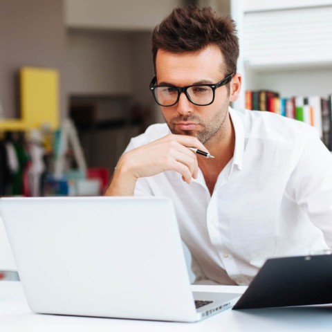 Hombre viendo la pantalla de su computador, representando el análisis, uso de herramientas y pensamiento estratégico enseñados en el curso de Marketing Digital de la USFQ.