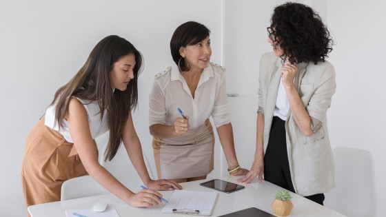 Mujeres profesionales trabajando juntas en un proyecto, representando el espíritu de liderazgo del certificado Mujeres Líderes de la USFQ.
