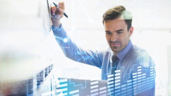 Hombre analizando datos y gráficos, habilidades enseñadas en el curso de Gestión de Riesgos para Entidades Financieras de la USFQ.